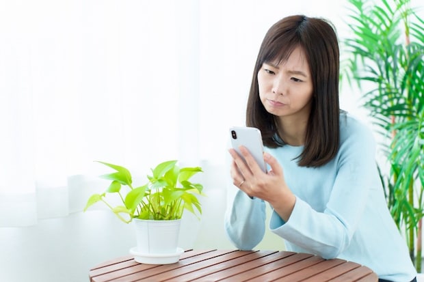 女性　スマホ　困った顔
