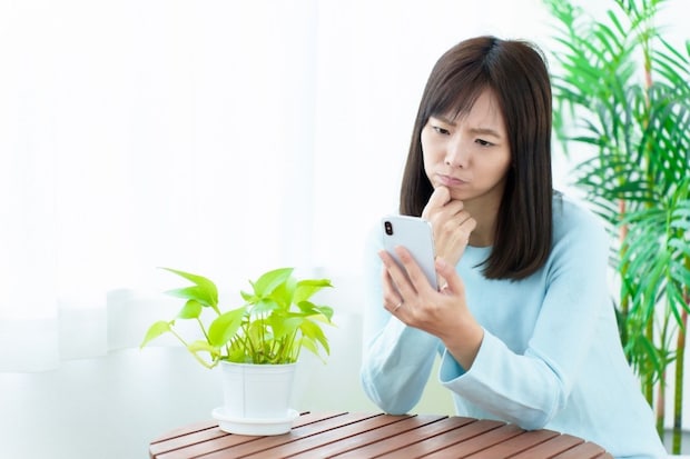 女性　スマホ　困った顔