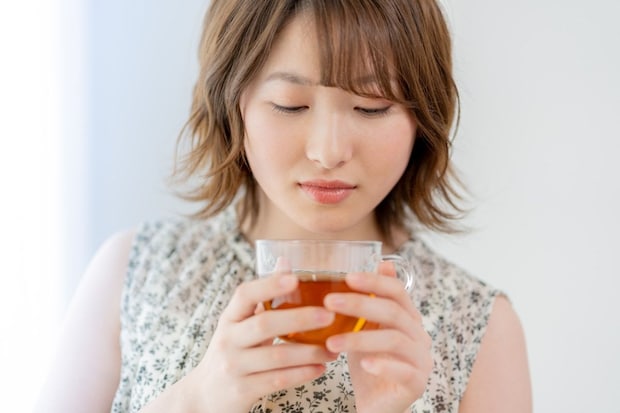 女性　俯く　茶髪　カップ