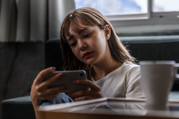 女性　茶髪　横顔　スマホ　暗い