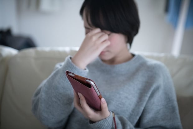 女性　眉間　スマホ　リビング