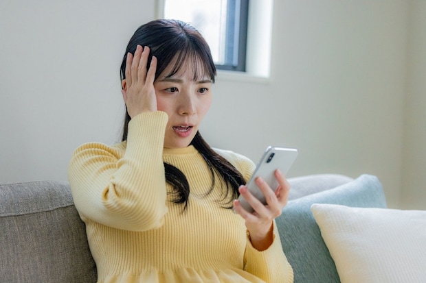 スマホ　ショック　女性　リビング　