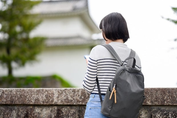 女性　リュック　旅行　スマホ