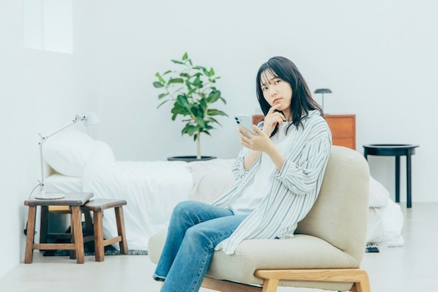 女性　　スマホ　リビング